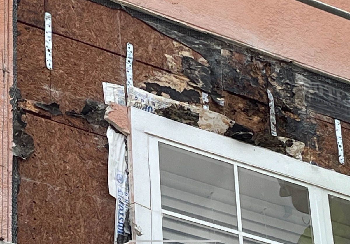 A person is working on a window on the side of a building.