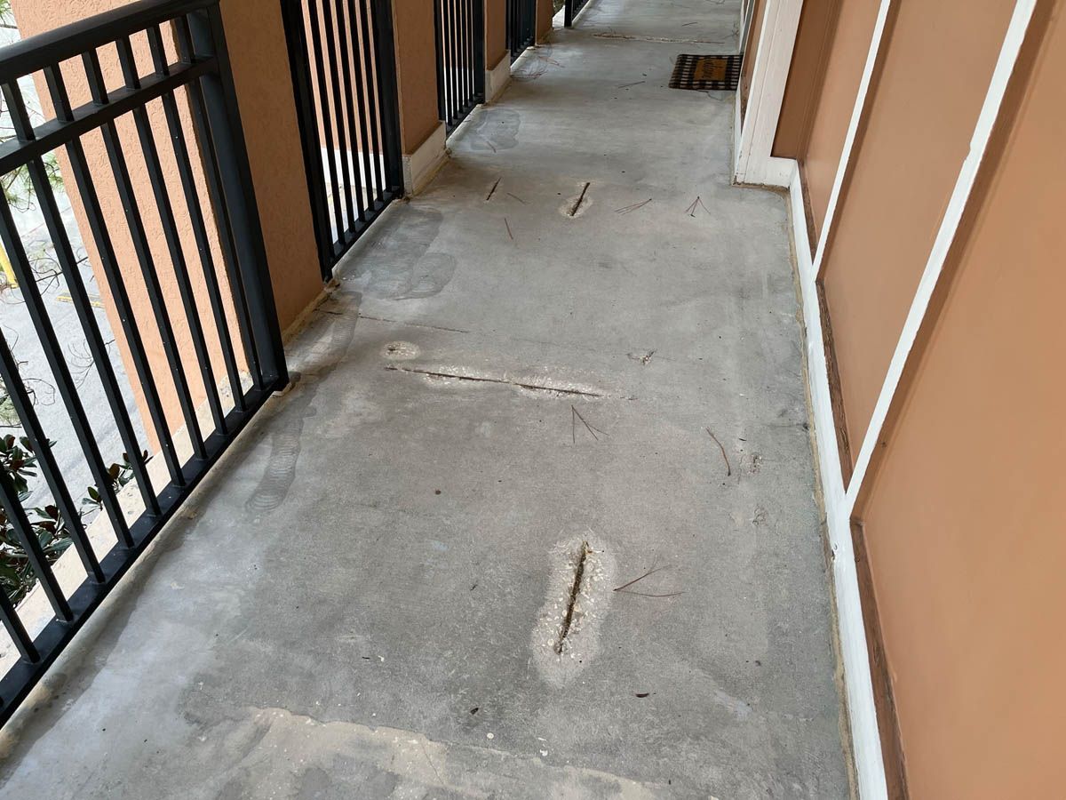 A hallway with a railing and a concrete floor
