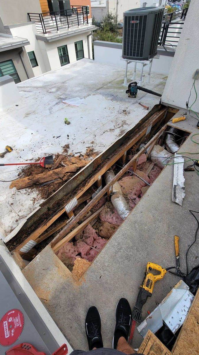 A person is standing on a roof with a hole in it.