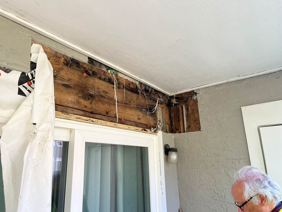 A man is standing in a room with a sliding glass door.