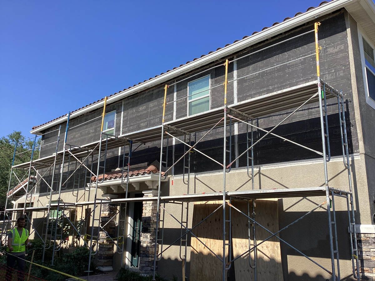 A house is being remodeled with scaffolding on the side of it.
