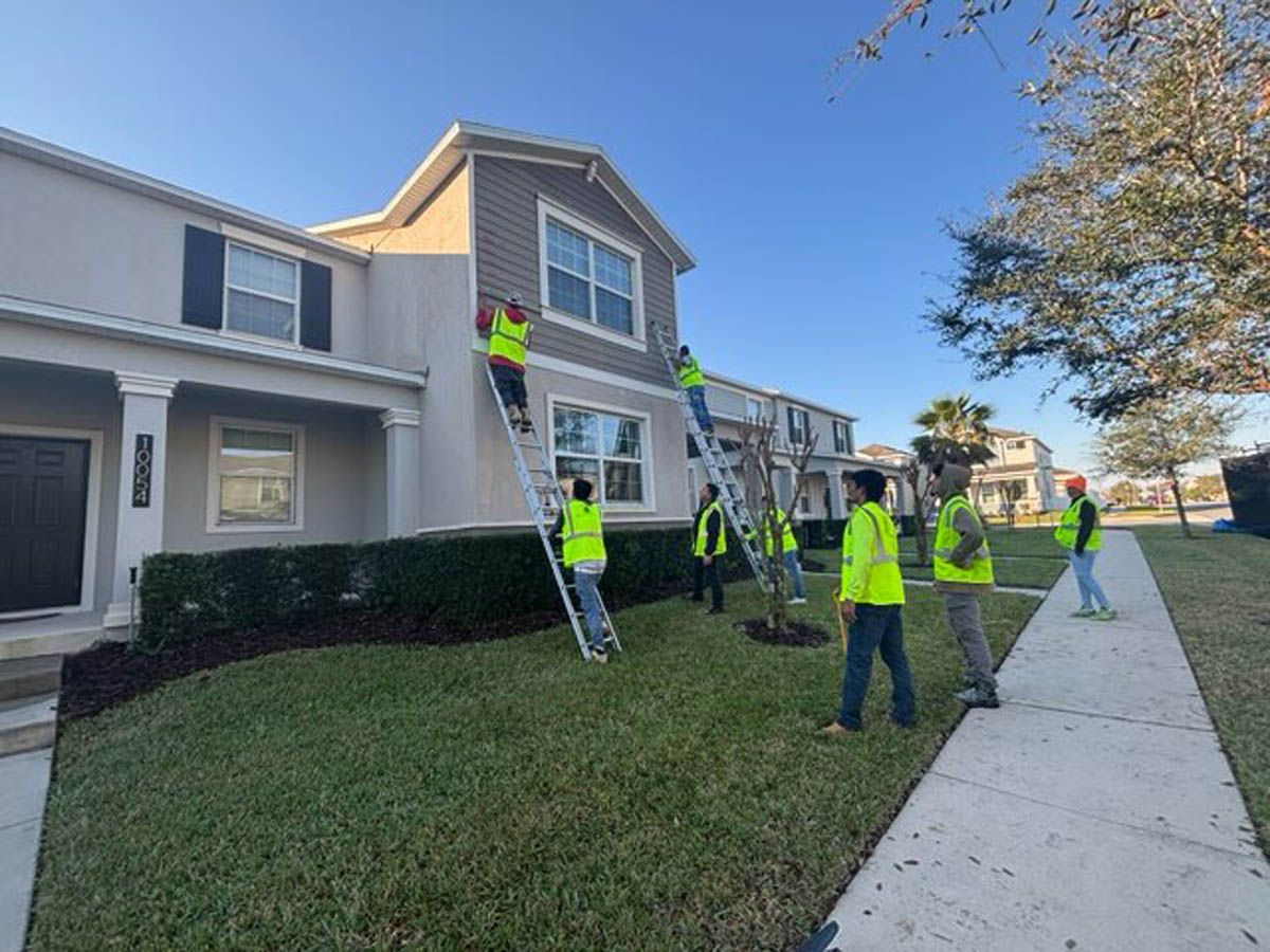 A group of people are painting the side of a house.