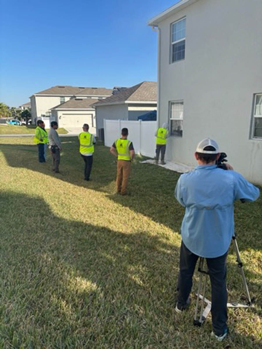 A group of people are standing in front of a house.