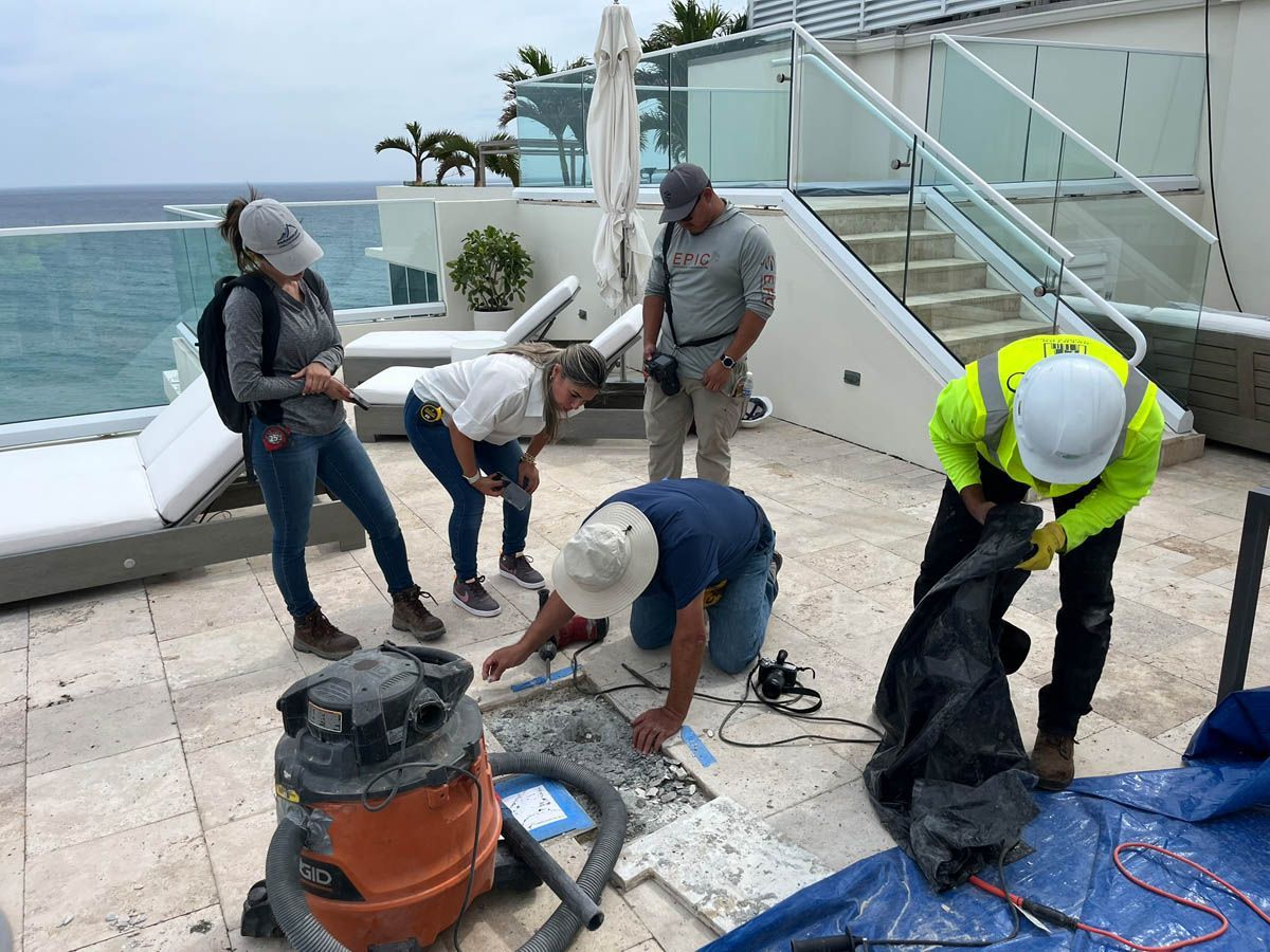 A group of people are working on a rooftop overlooking the ocean.