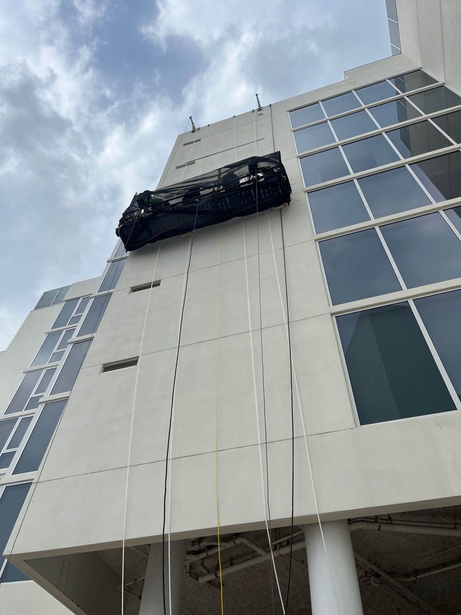 A car is being lifted up to the top of a building