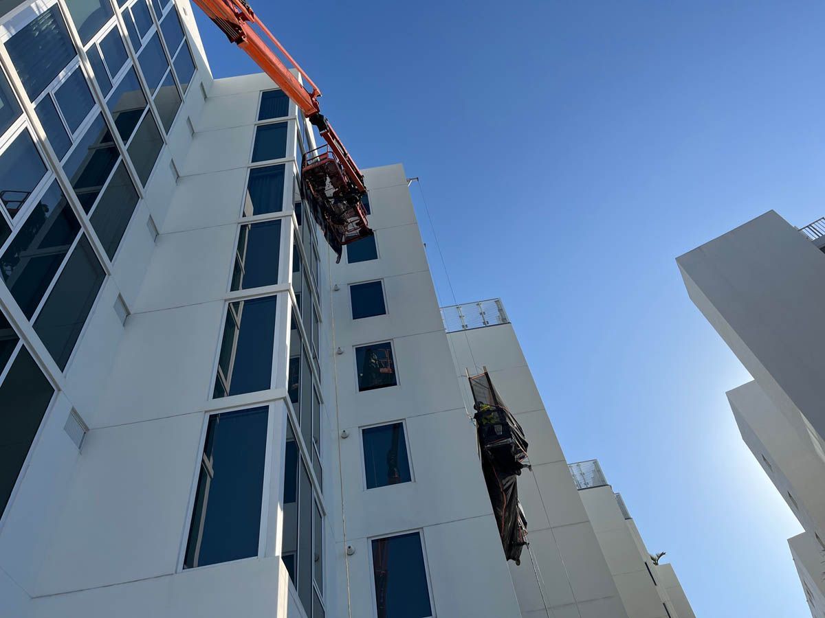 A crane is lifting a piece of wood from the side of a building