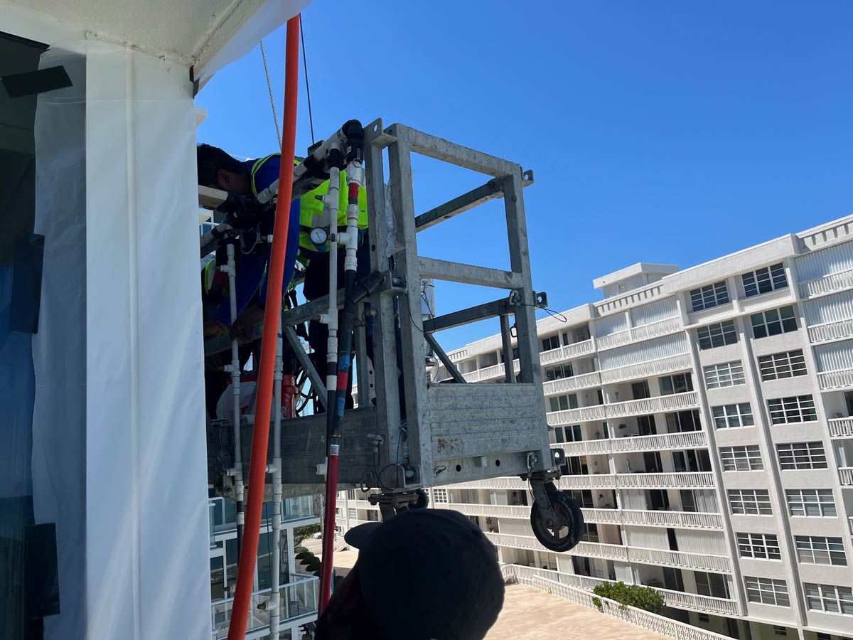 A man is standing on a ladder in front of a building.