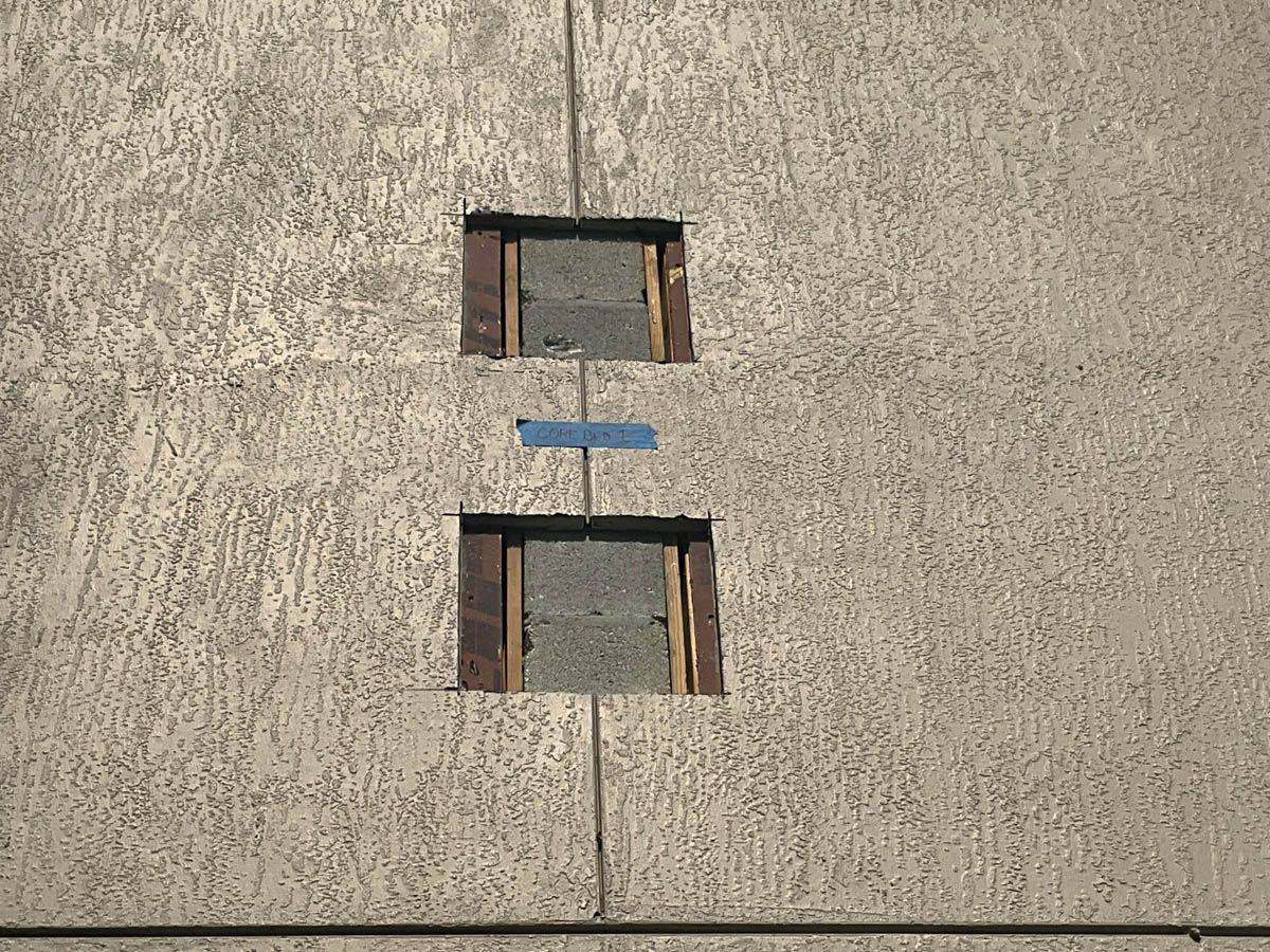 A close up of a concrete wall with two holes in it.