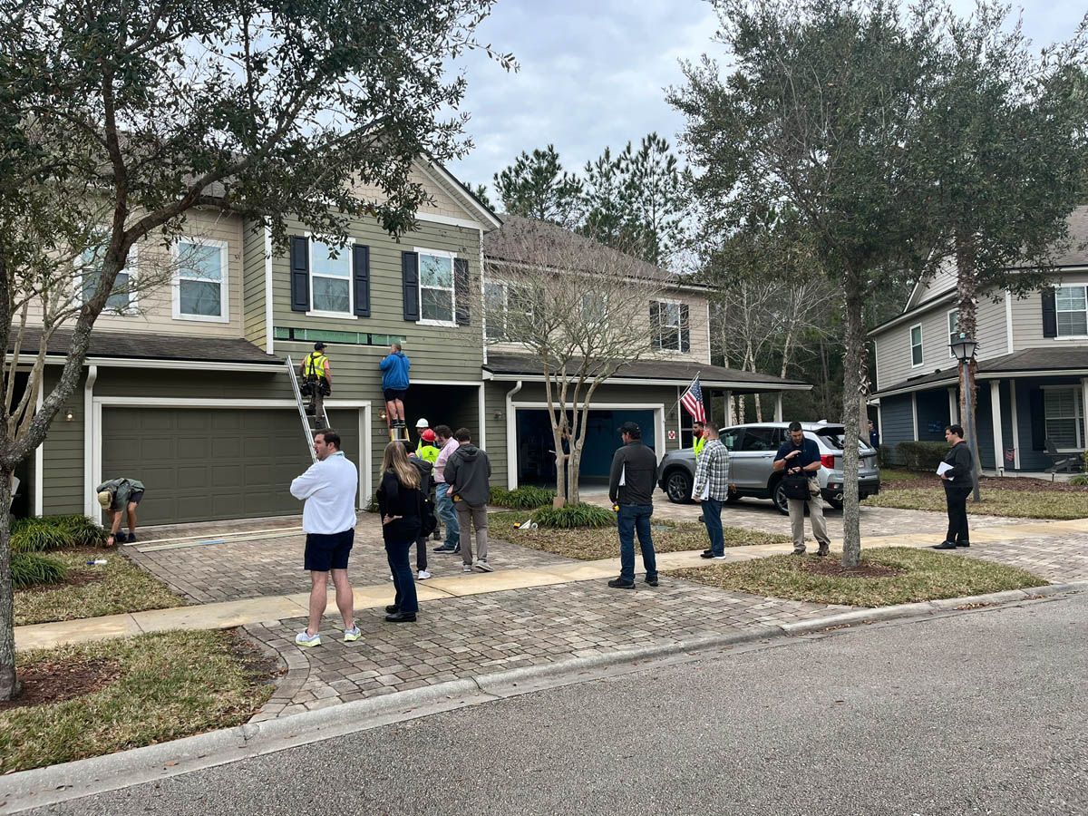 A group of people are standing outside of a house.