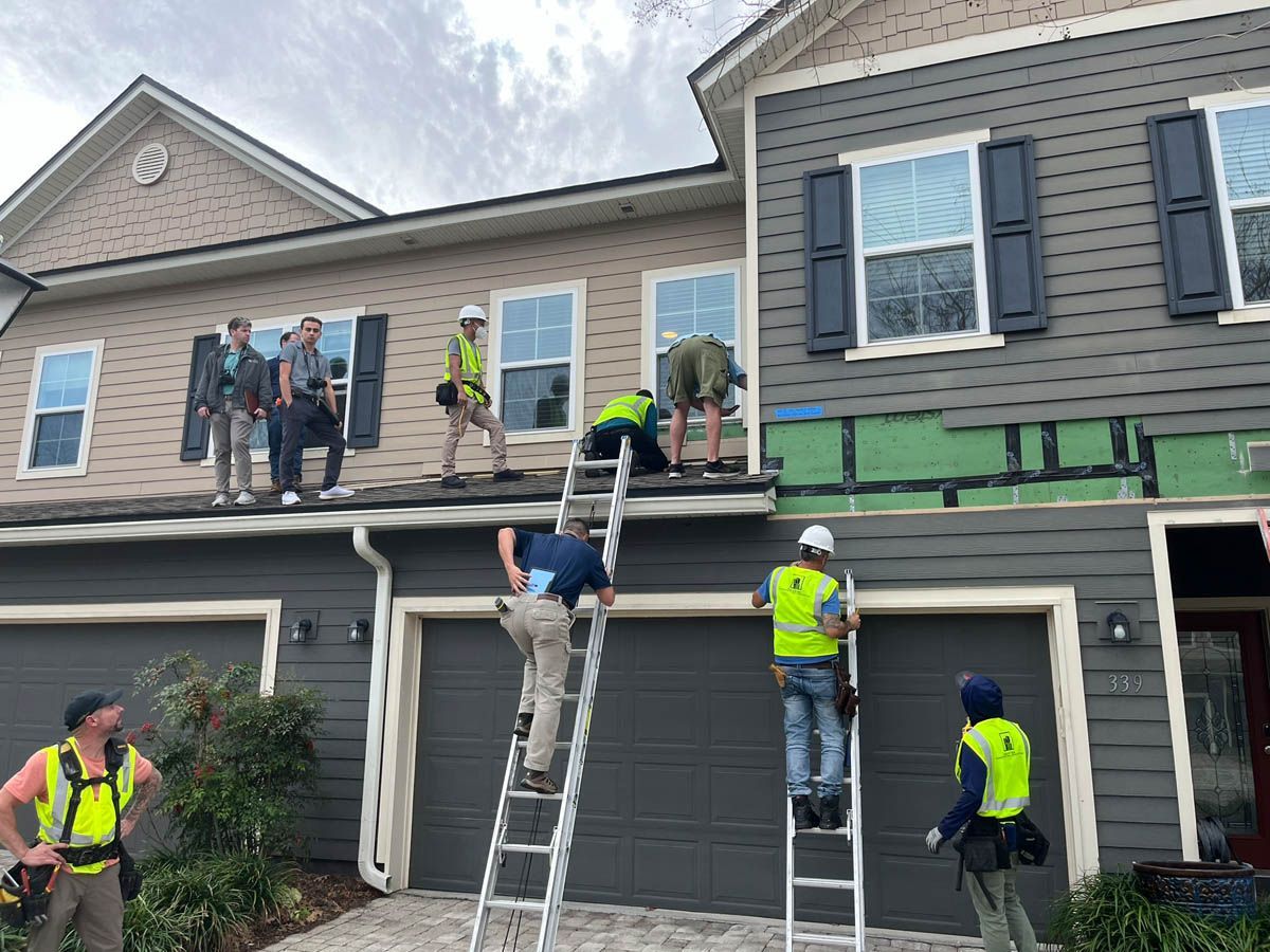A group of men are working on the roof of a house.