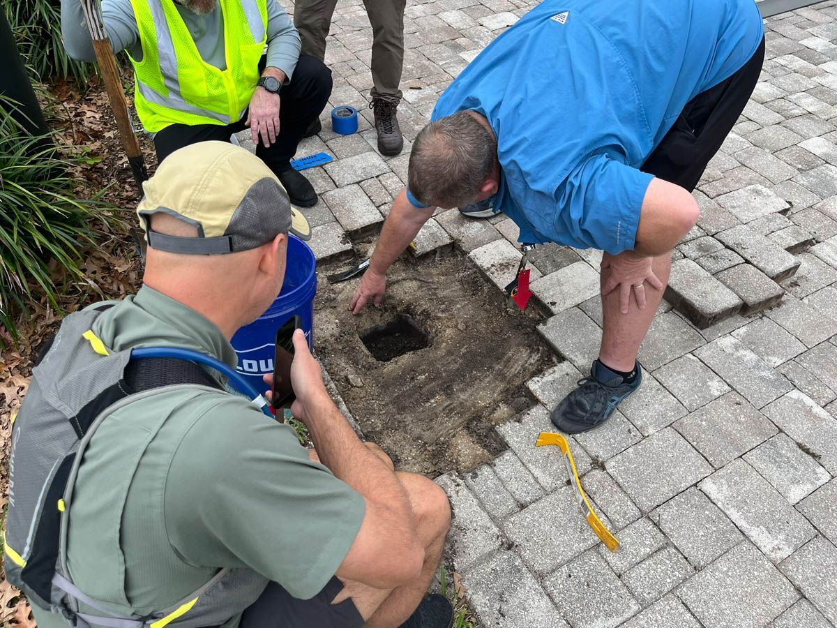 A group of men are digging a hole in the ground.