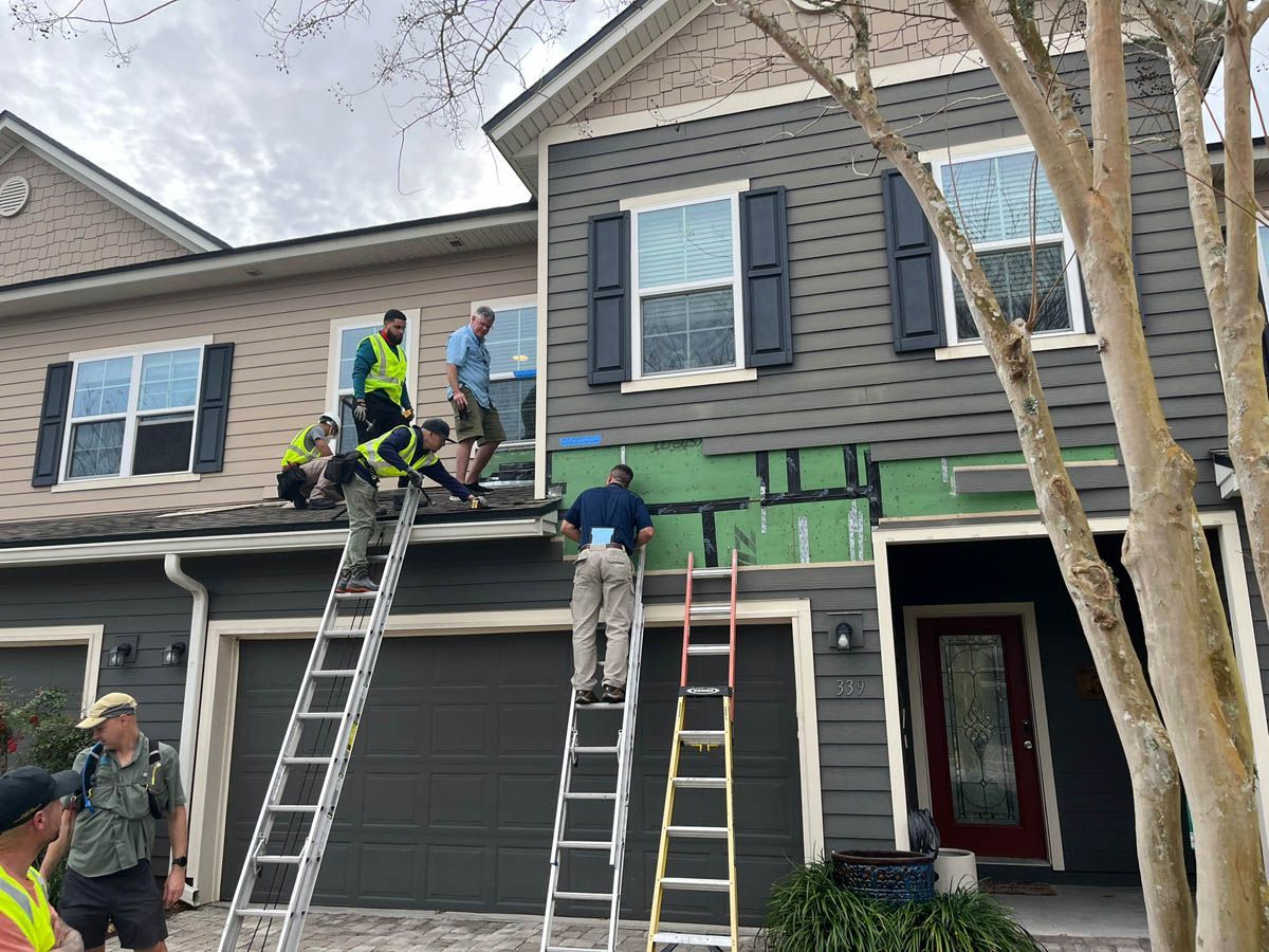 A group of men are working on the side of a house.