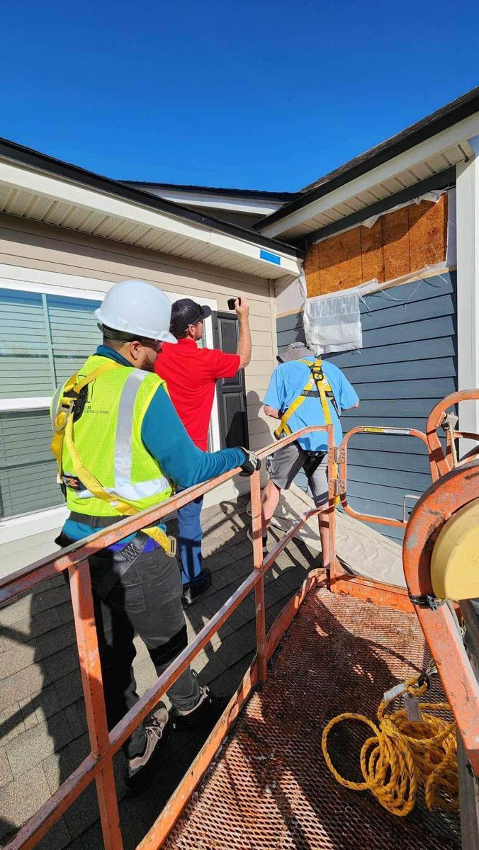 A group of construction workers are working on a house.