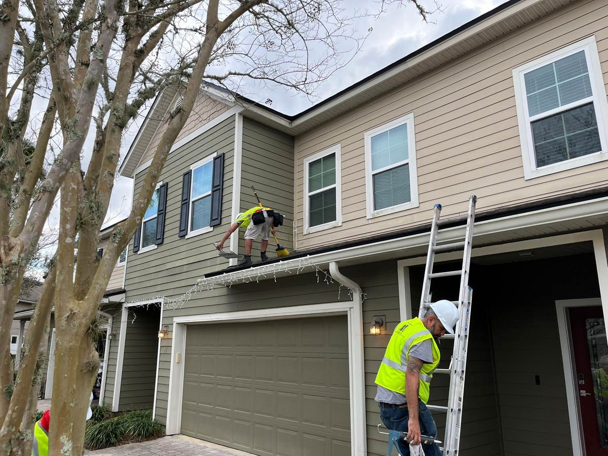 A couple of men are working on the side of a house.