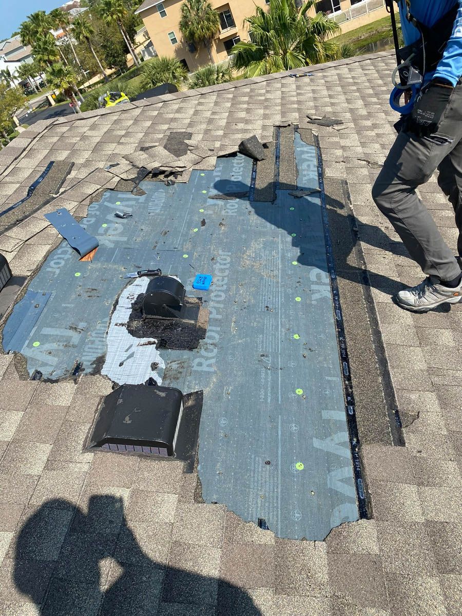 A man is standing on top of a roof with a hole in it.