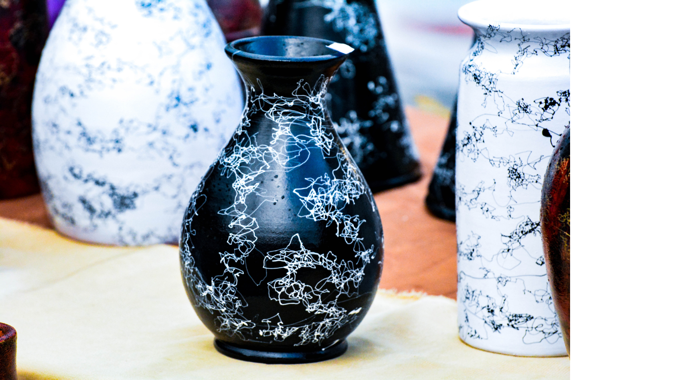 A group of black and white vases are sitting on a table.