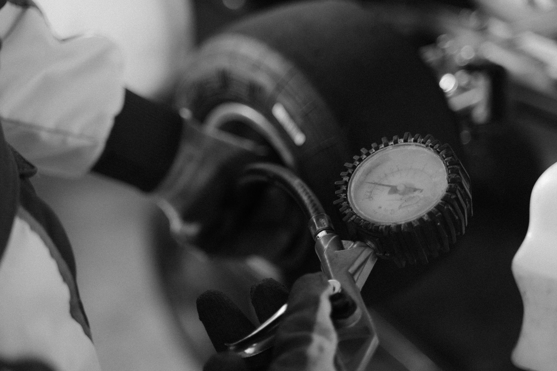 A black and white photo of a person cutting a cupcake with scissors.