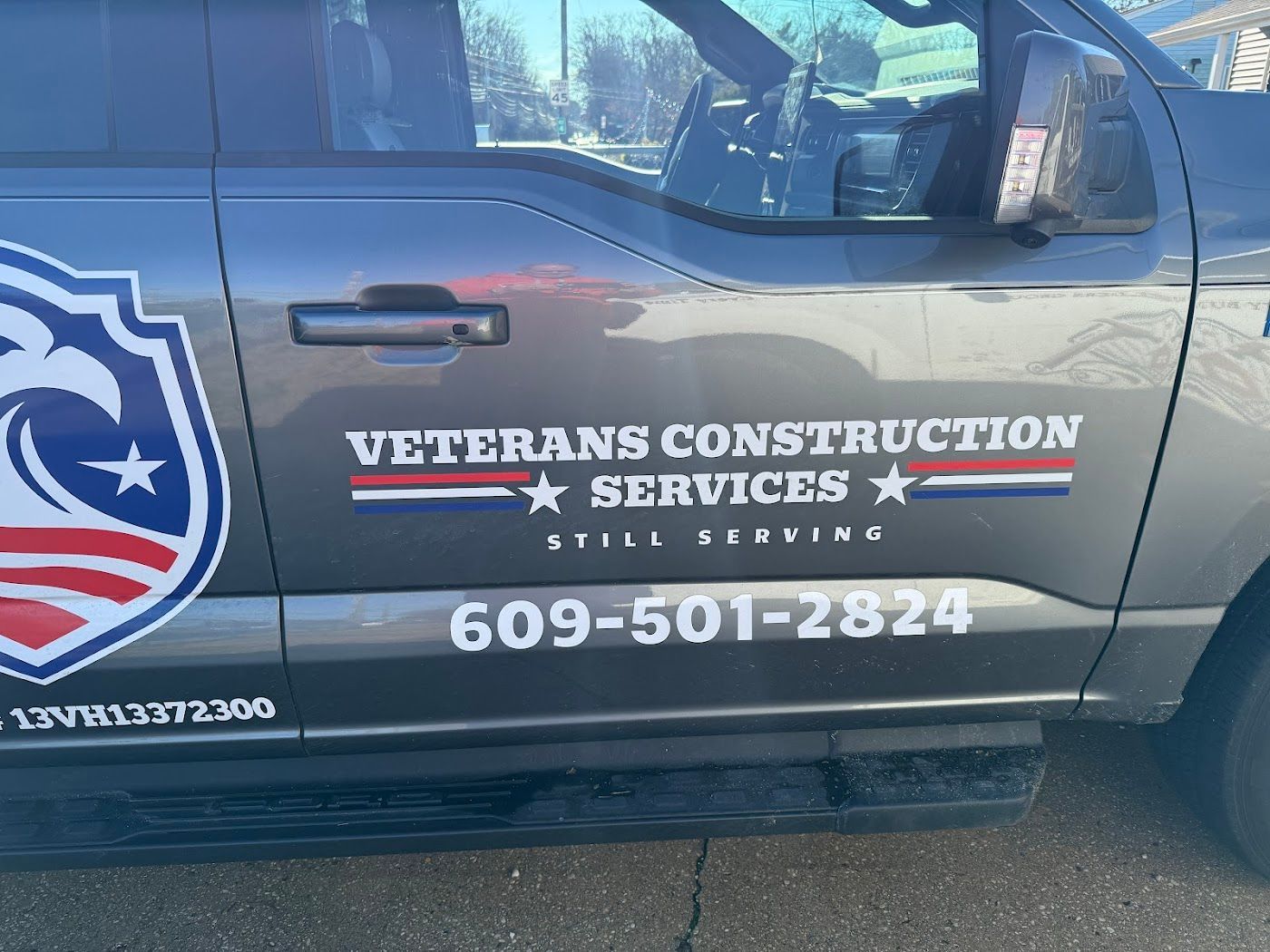Gray truck with Veterans Construction Services logo and phone number.