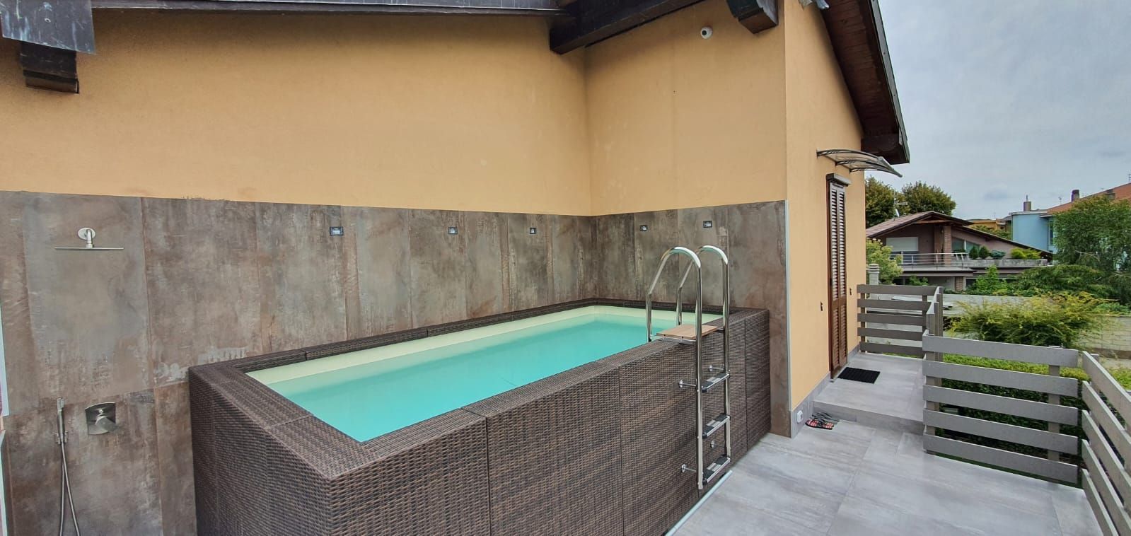 Una grande piscina è costruita sul lato di un edificio.