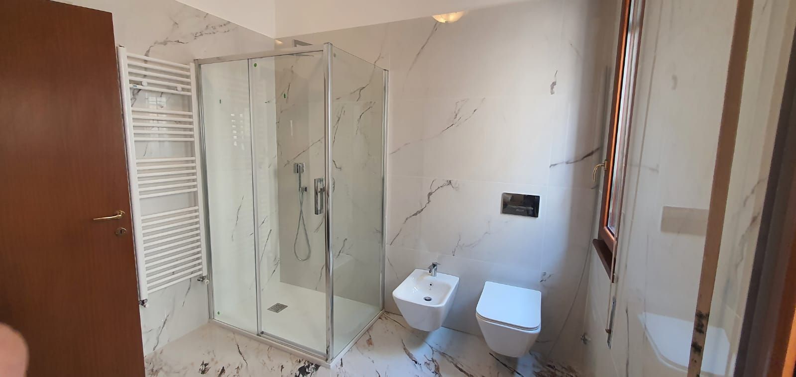 Un bagno con wc, bidet e box doccia.