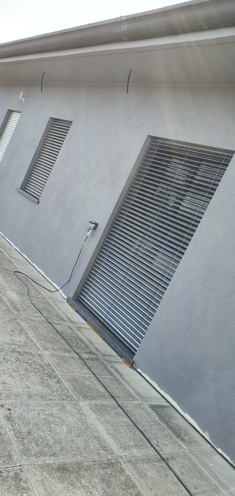 Un edificio con molte finestre e persiane sui lati.