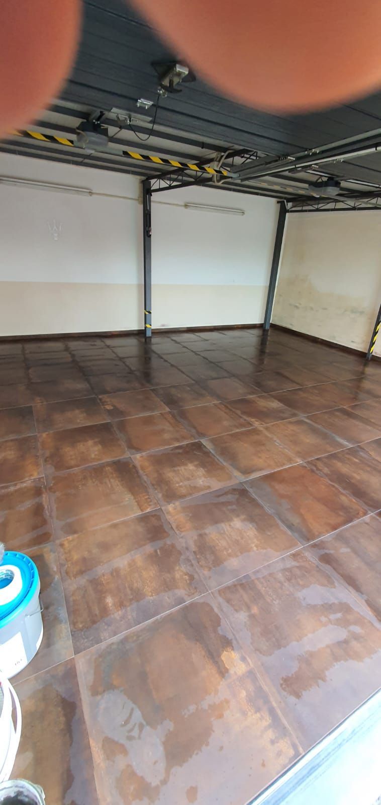 Una persona sta scattando una foto del pavimento piastrellato di un garage.