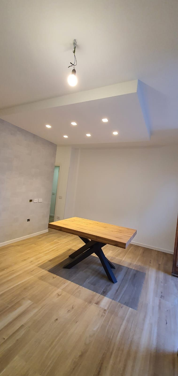 C'è un tavolo di legno in mezzo alla stanza.