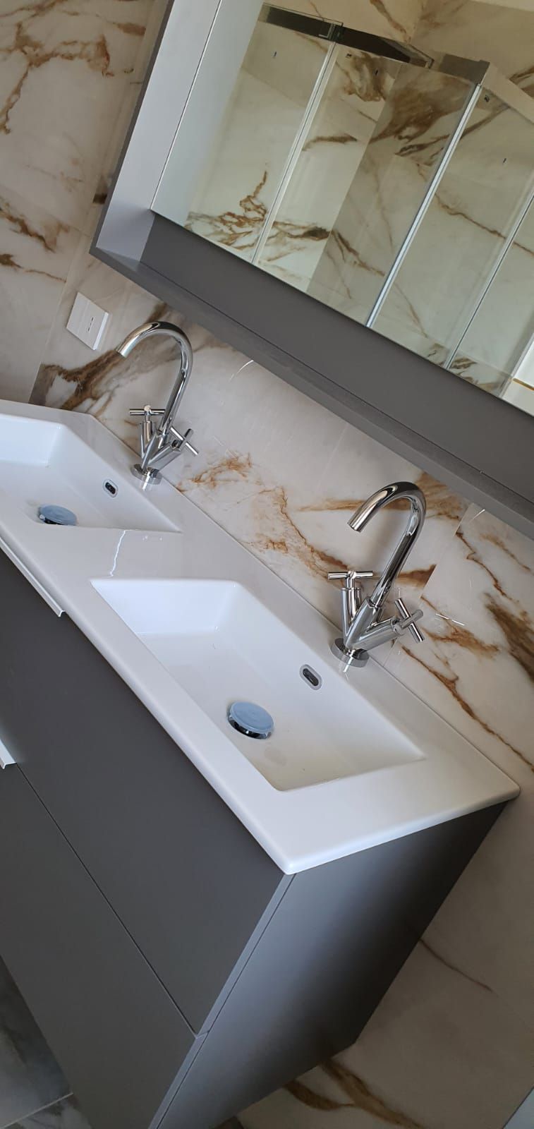 Un bagno con due lavandini e uno specchio.