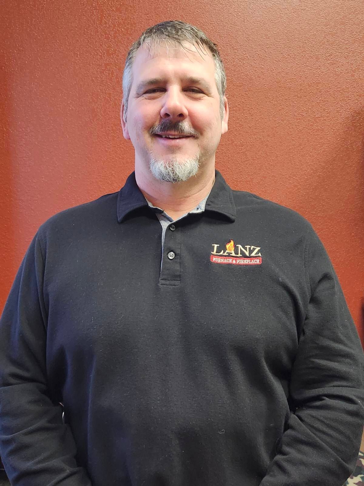 A man wearing a black shirt with the word lanz on it