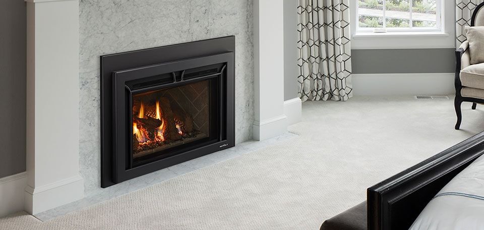A fireplace is sitting in a living room next to a window.