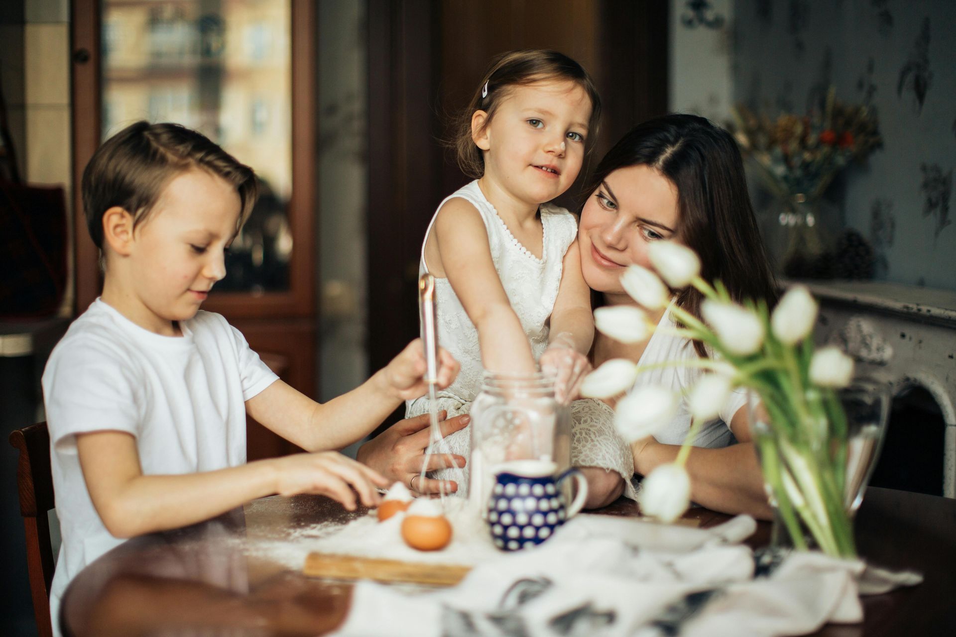 A woman and two children are sitting at a table.