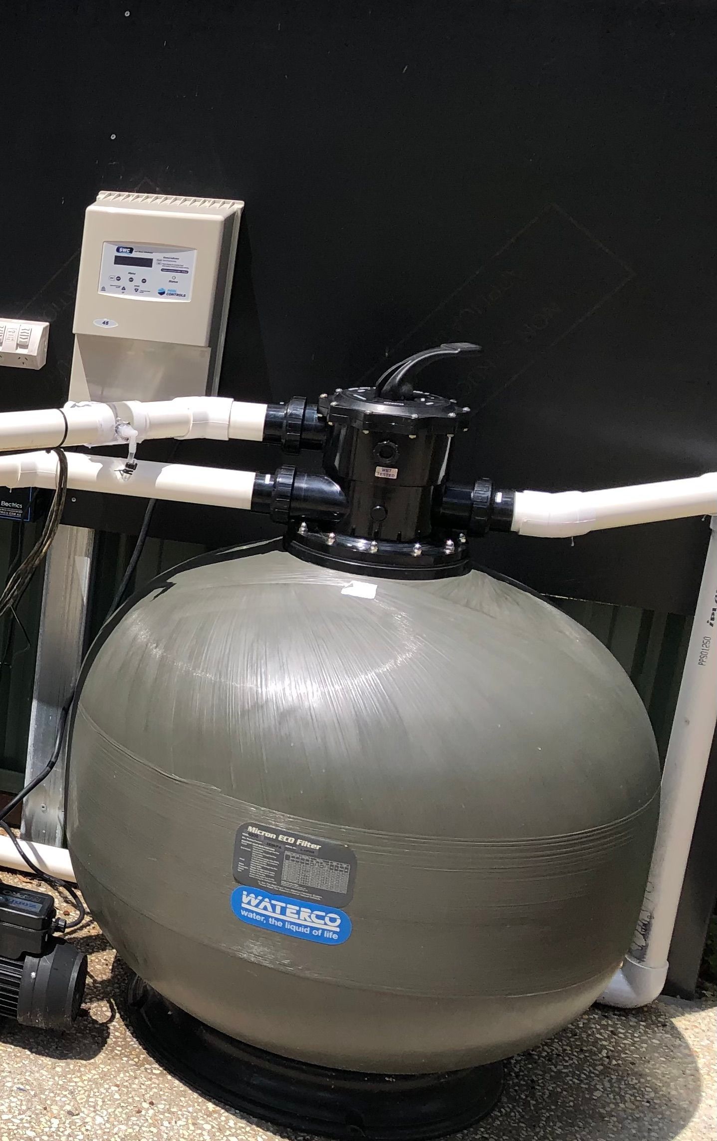 A grey pool filter is sitting on the ground — Mediterranean Custom Pools In Kialla, VIC