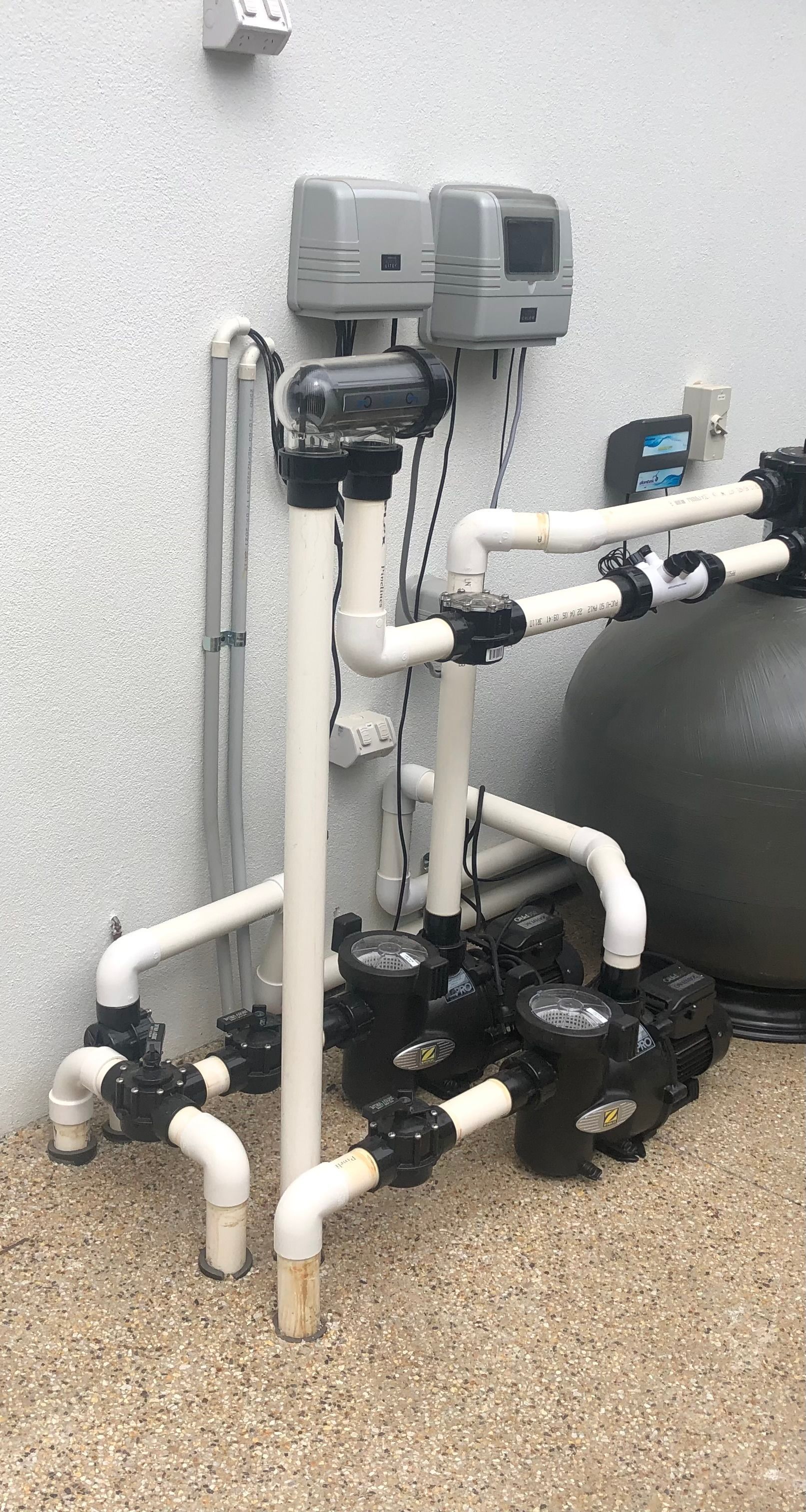 Lots of pumps are connected on a white wall — Mediterranean Custom Pools In Kialla, VIC