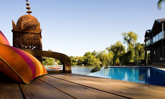 A Wooden Deck Overlooking A Large Swimming Pool — Mediterranean Custom Pools In Kialla, VIC