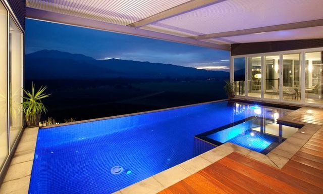 A Large Swimming Pool With A View Of The Mountains At Night — Mediterranean Custom Pools In Kialla, VIC