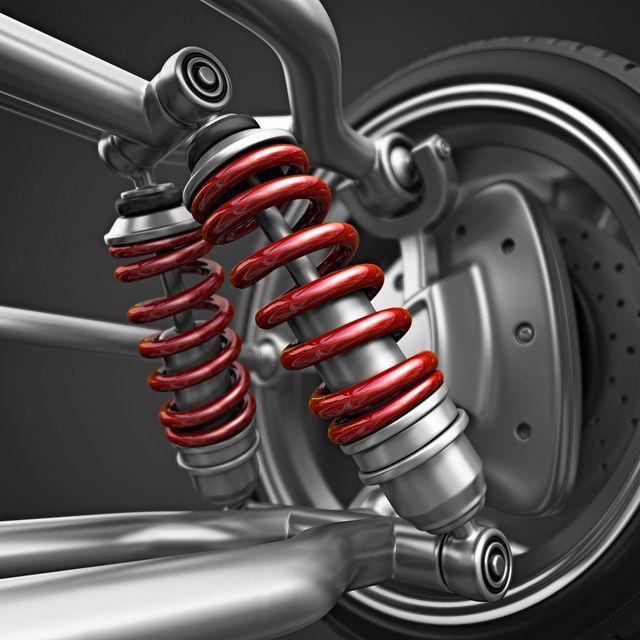 A close up of a car suspension with red springs