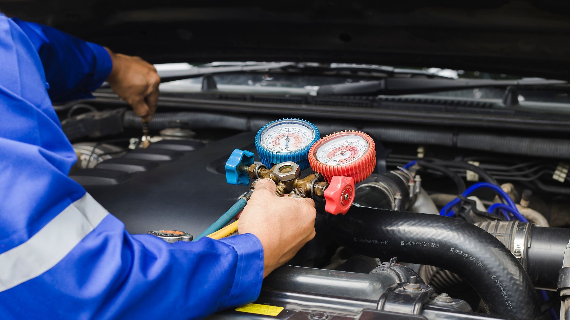 A man is working on the engine of a car.