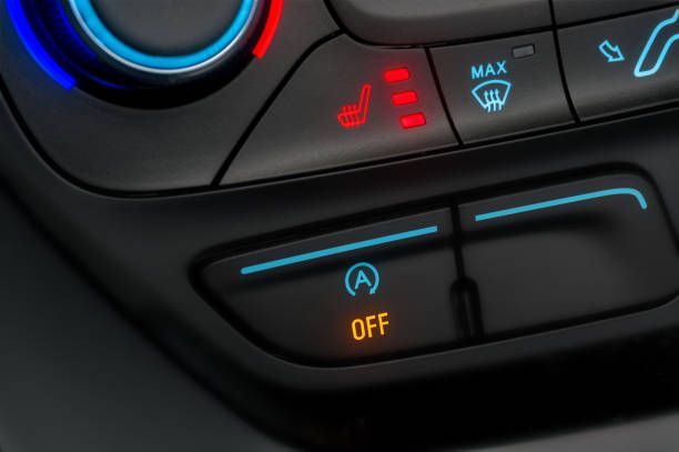A close up of a car climate control with the off button lit up