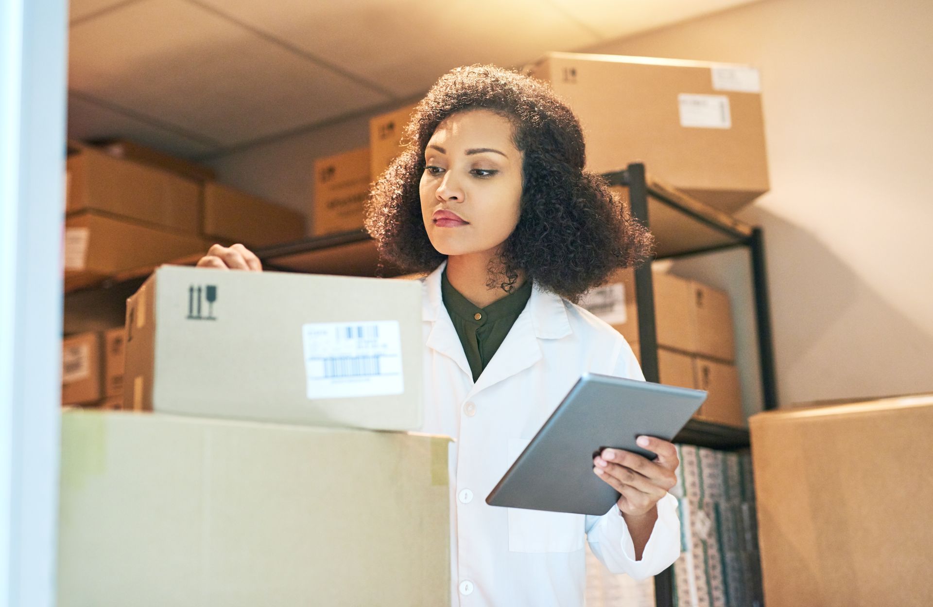 A pharmacist checking shipping for medical supplies as part of health care logistics.