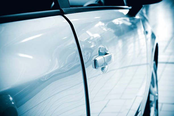 A close up of a car door in a showroom.