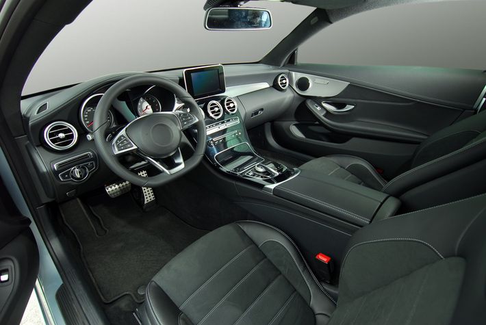 The interior of a car with a steering wheel and seats