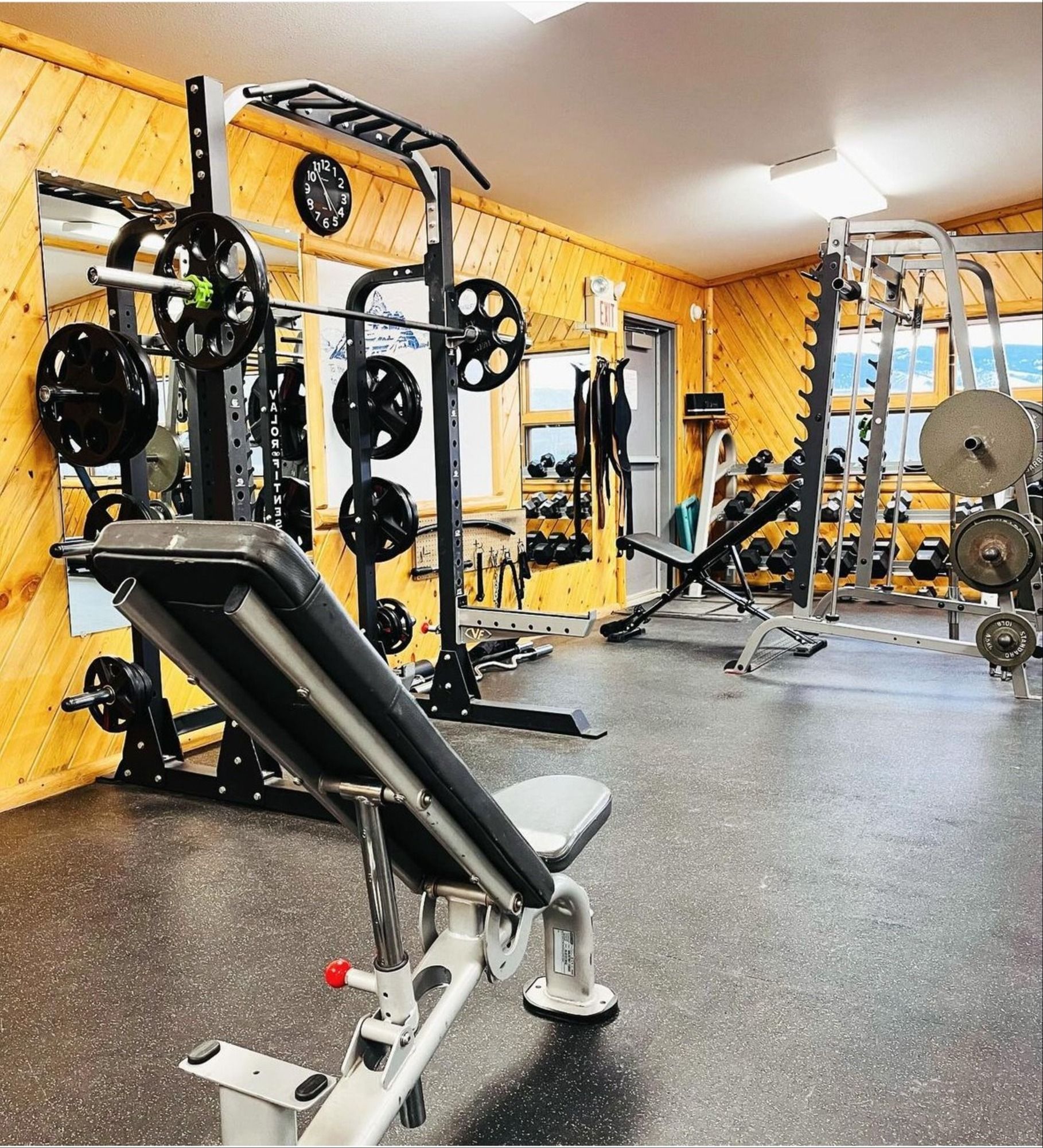 A gym filled with lots of equipment including a bench