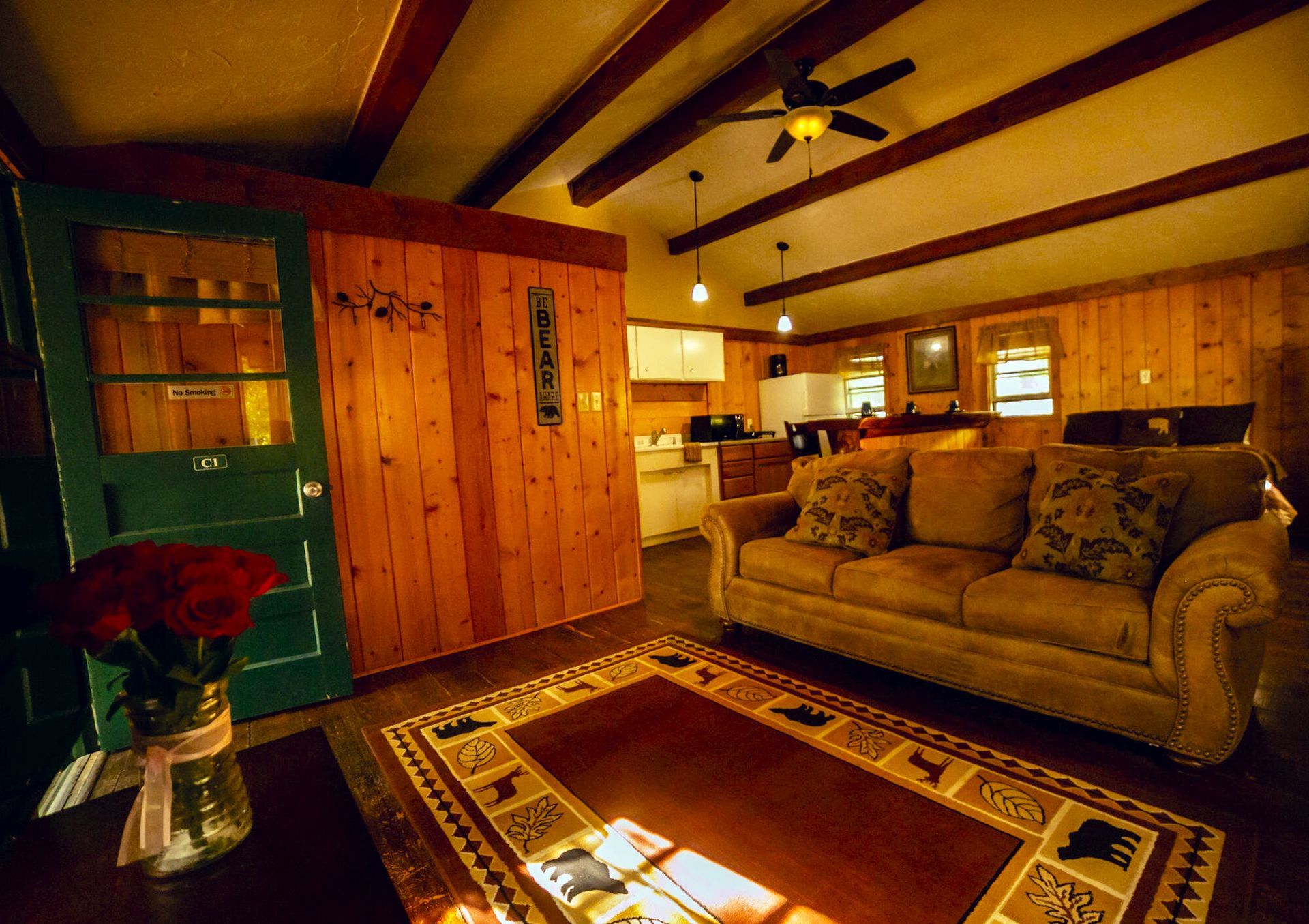 A living room with a couch and a rug and a sign that says home