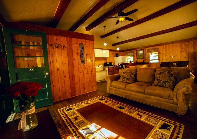 A living room with a couch and a rug and a sign that says home
