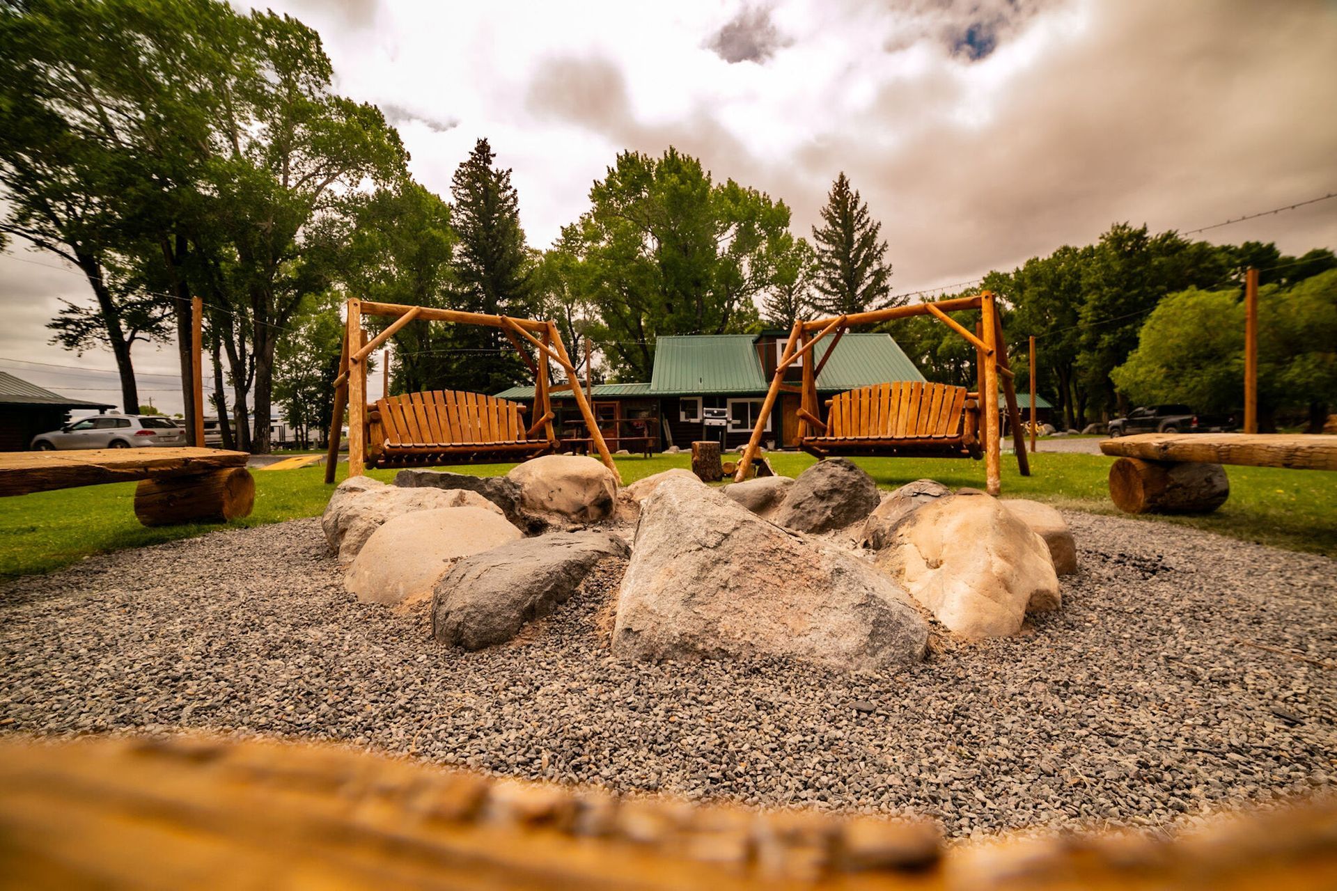 A fire pit surrounded by rocks and benches in a park.