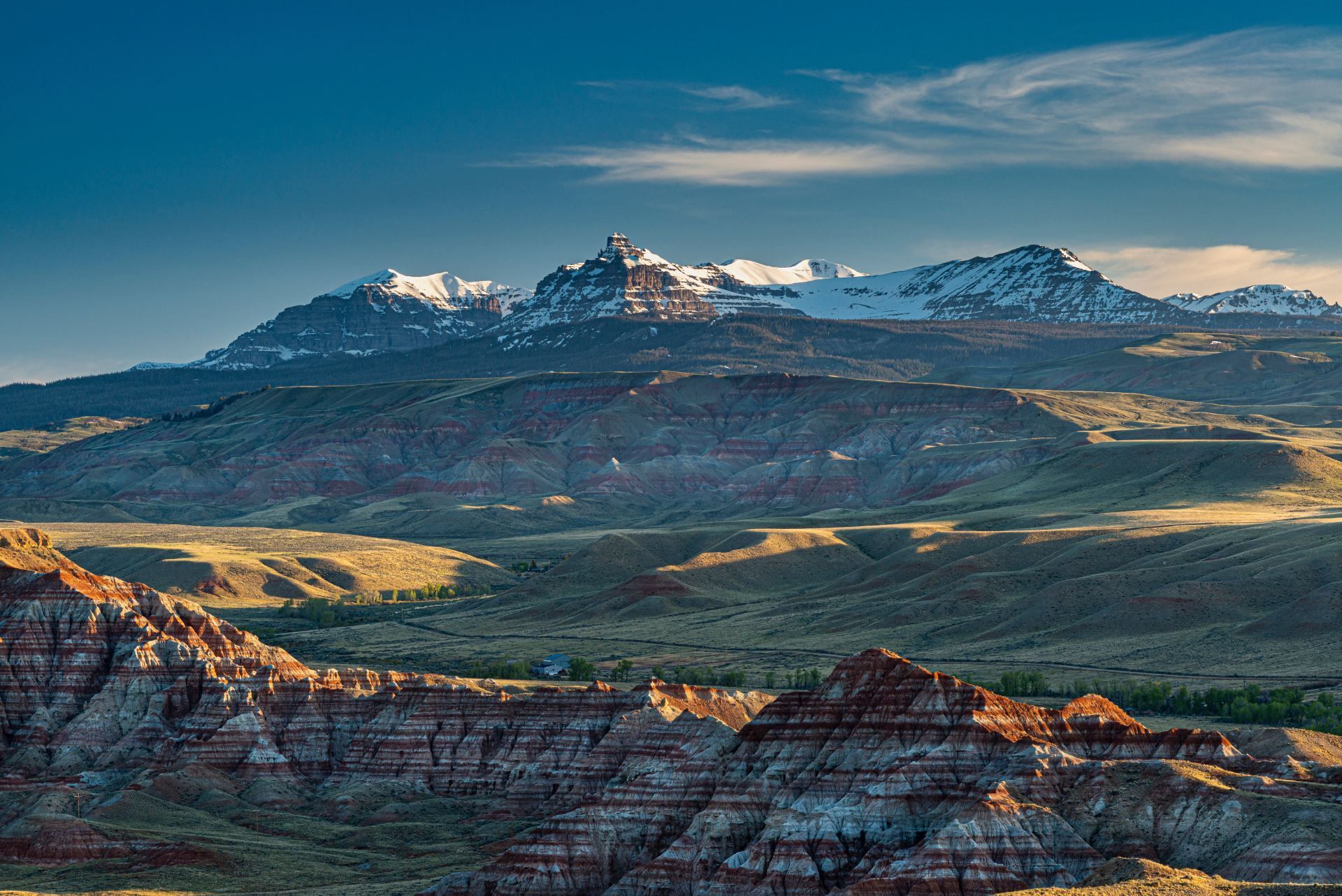 A landscape with mountains in the background and a blue sky