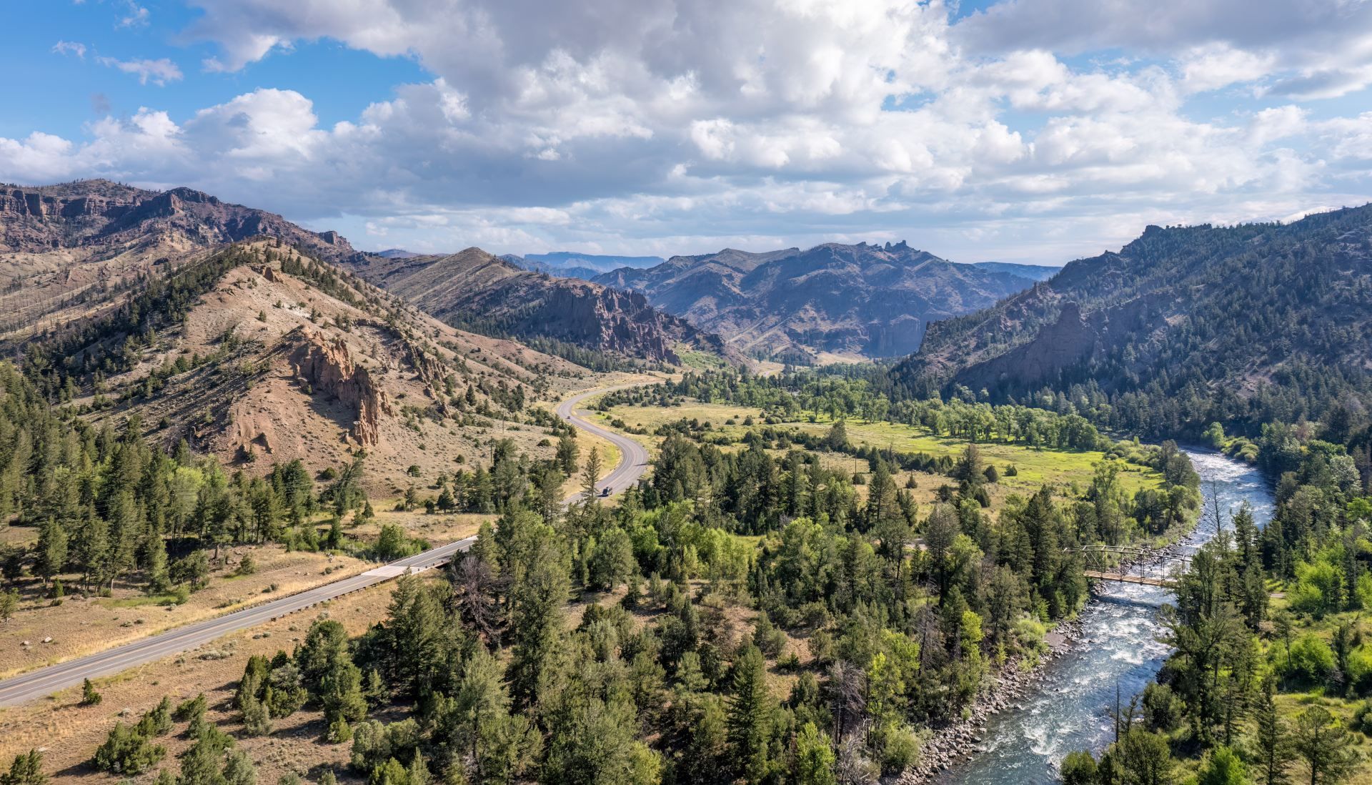 An aerial view of a river surrounded by mountains and trees.
