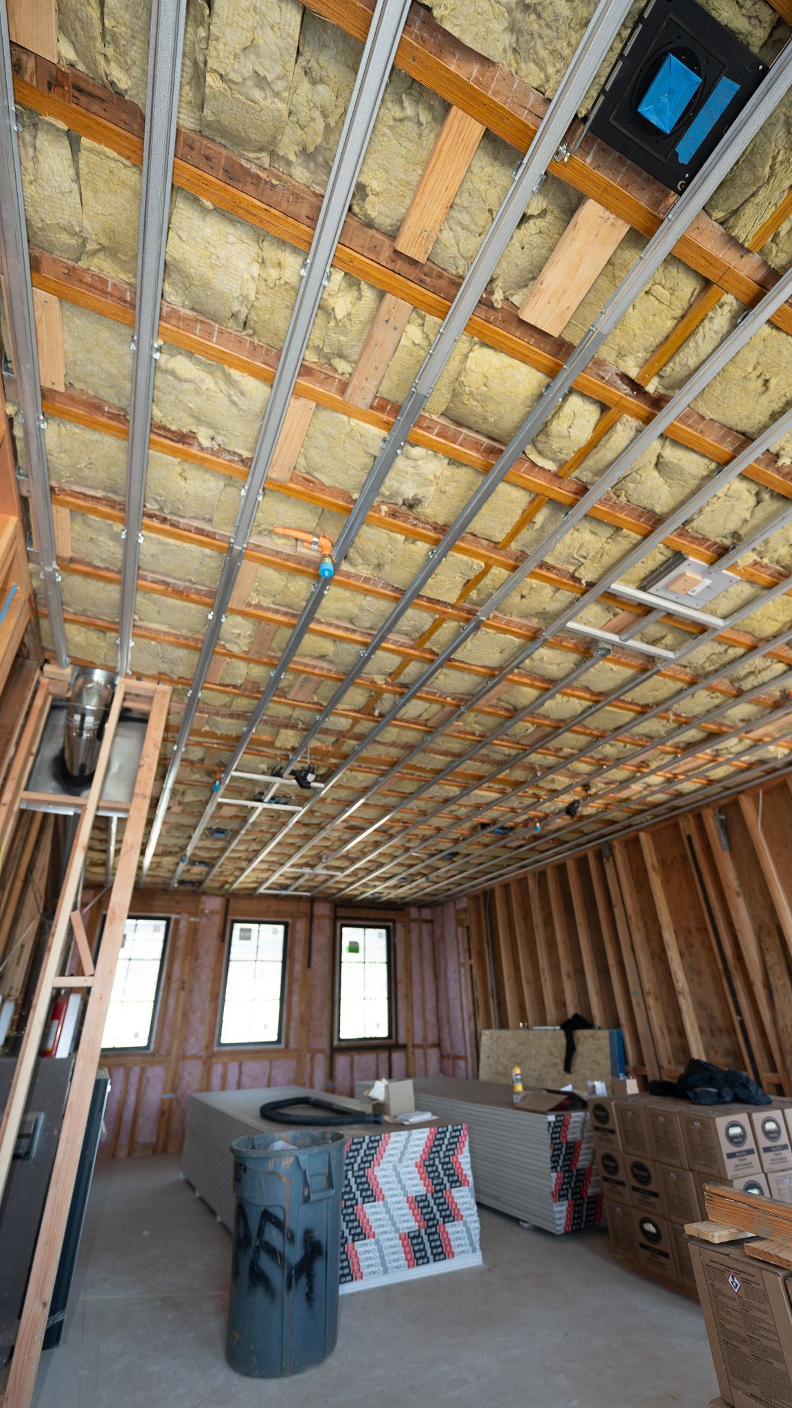 Insulated attic ceiling with two skylight windows and exposed framing