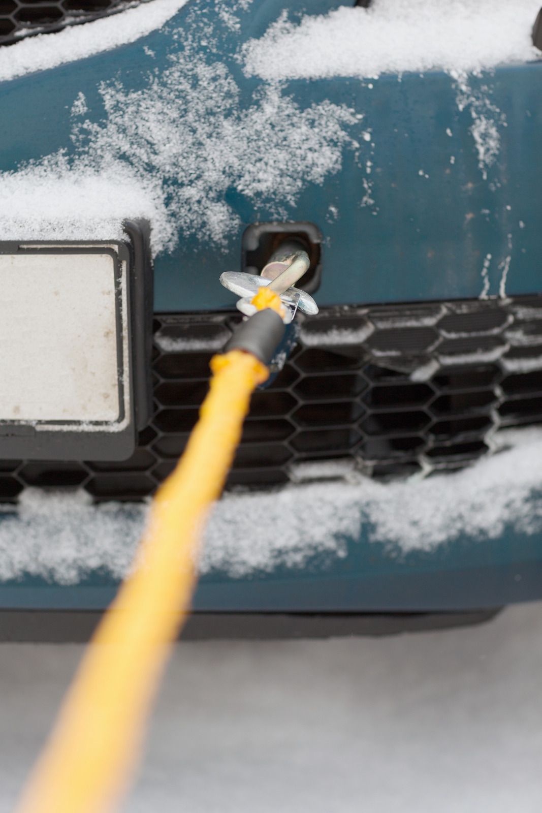 A close up of a car with a yellow hose attached to it.