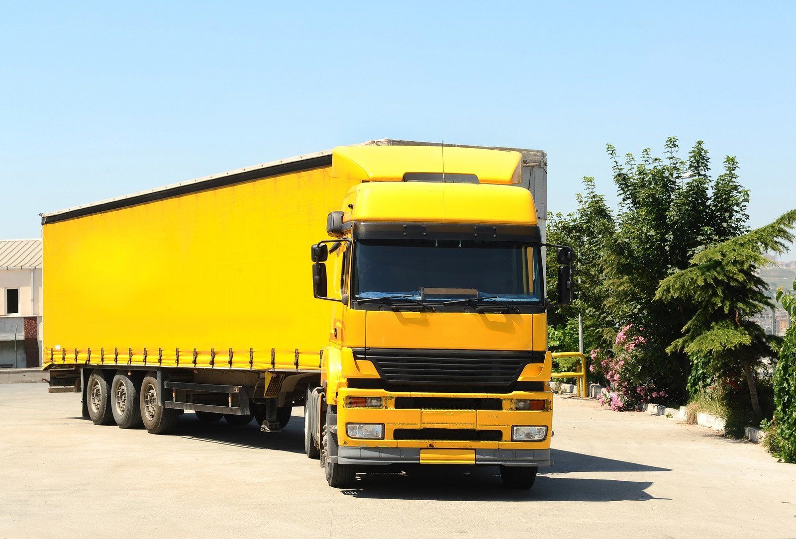 Yellow semi-truck parked on a sunny day.
